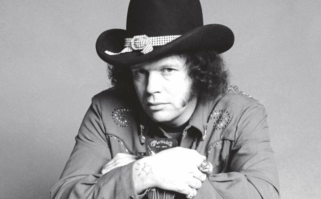 David Allan Coe performing live on stage with guitar