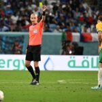 Referee issuing yellow card during FIFA World Cup match