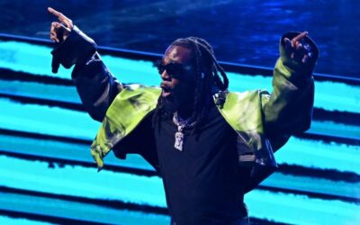 Burna Boy spraying dollar notes on Adewale Ayuba during a live Fuji music performance