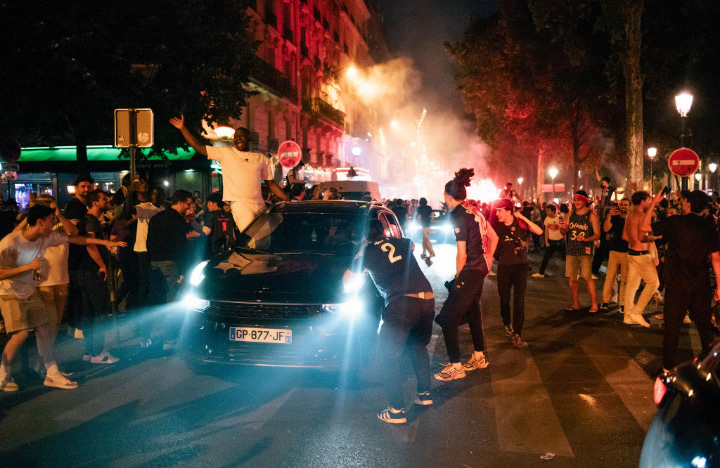 PSG supporters celebrating Champions League victory amid clashes with police in Paris