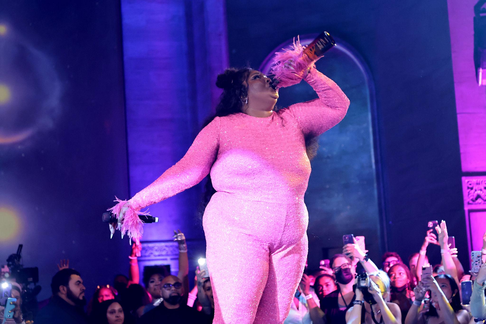 Lizzo performing on stage while discussing the impact of streaming on her music career