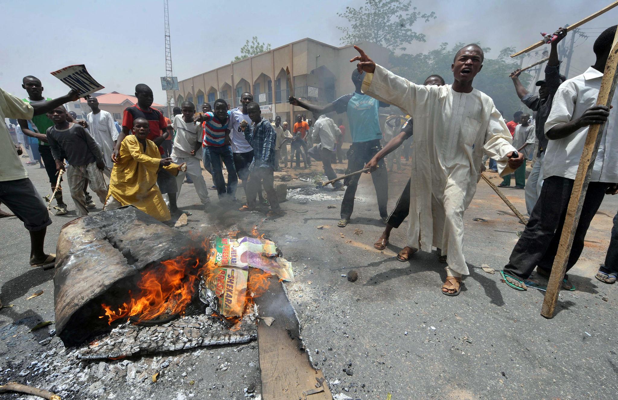 Residents in Nasarawa burning Governor Abdullahi Sule campaign posters and APC brooms during protest