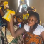 Residents in Oyo State holding food items during an outreach event while expressing political support.